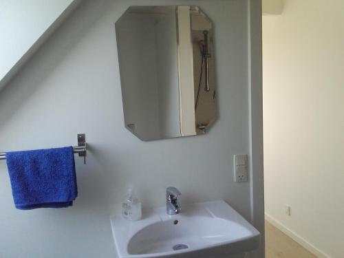 a white bathroom with a sink and a mirror at Pension Stenvang in Onsbjerg