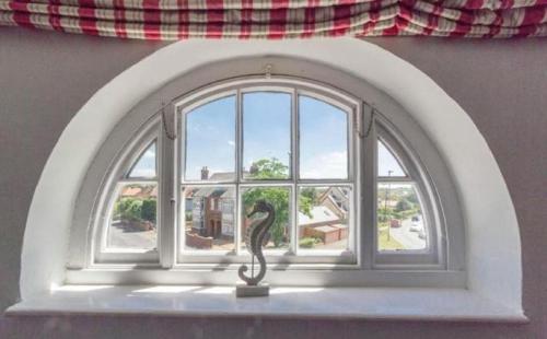 an arched window with a cat statue in front of it at The Globe Inn in Wells next the Sea
