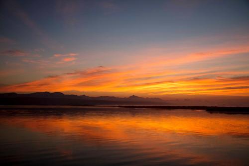 a sunset over a large body of water at No1 Sangaree in Plettenberg Bay