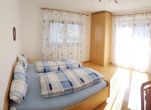 - un lit avec 2 oreillers dans l'établissement Appartements Oberleiter, à Valdaora