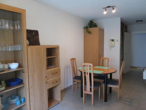 a kitchen and dining room with a table and chairs at De Panne Plaza in De Panne