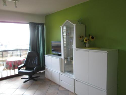 a room with a desk and a chair and a window at De Panne Plaza in De Panne