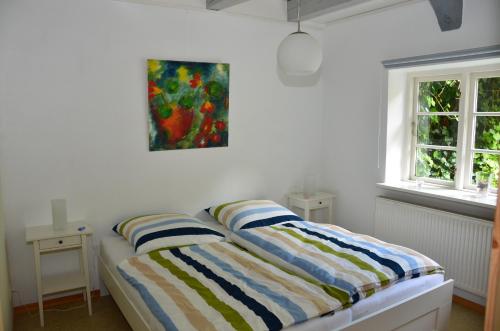 a bedroom with a bed with a painting on the wall at Wohnen Unter Reet in Niebüll