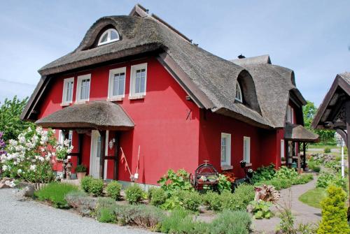 Neu ReddevitzにあるKarolas Landhus unterm Reetdachの茅葺き屋根の赤い家