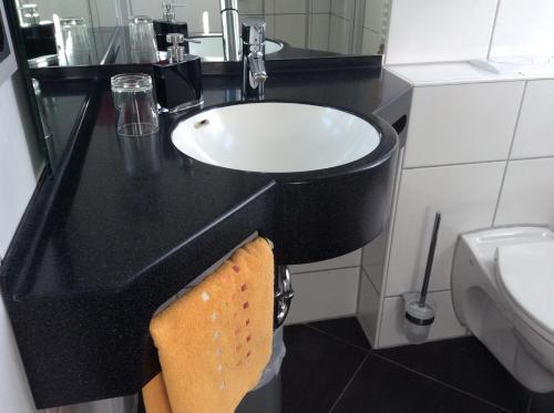 a bathroom with a black counter and a sink at Hotel-Pension Berger in Heidelberg