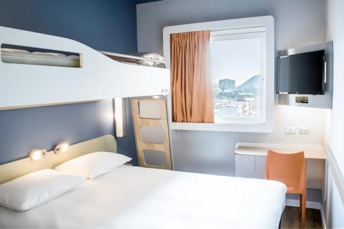 a bedroom with a bed and a desk and a bunk bed at ibis budget Copiapo in Copiapó