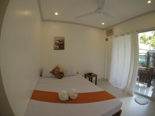 un dormitorio con una cama y una ventana en Neela Tourist Lodge, en El Nido