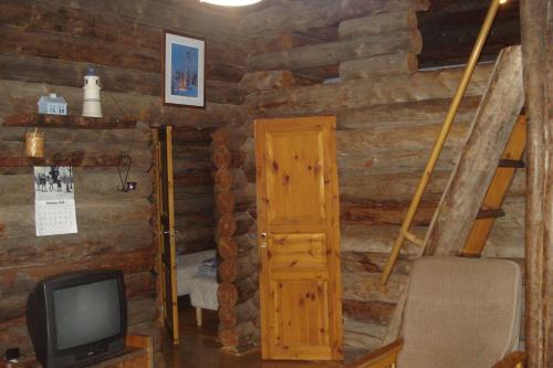 a log cabin with a television and a room at Hakamajat Cottages in Syöte
