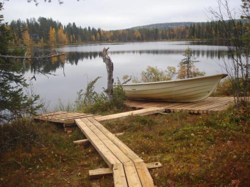 a boat sitting on a dock next to a lake at Hakamajat Cottages in Syöte