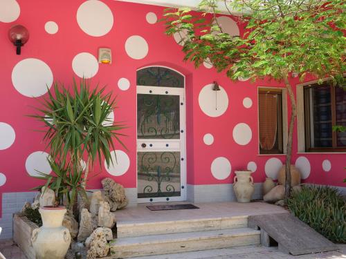 a pink house with white polka dots on it at B&B Vento di Scirocco in Favara