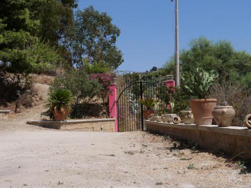 a gate with a bunch of pots in a garden at B&B Vento di Scirocco in Favara