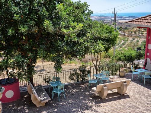 a patio with tables and chairs and a tree at B&B Vento di Scirocco in Favara