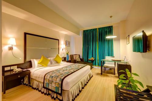 Habitación de hotel con cama grande y escritorio. en Sonotel Hotels & Resorts Pvt Ltd, en Dhanbād