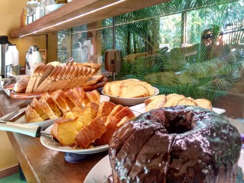 un tavolo con molti tipi diversi di dolci e torte di Pousada Florence a Ilhabela