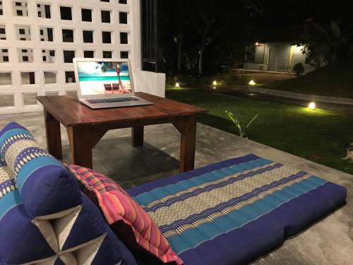 a laptop computer sitting on a table next to a couch at Kiri Tawan in Baan Tai