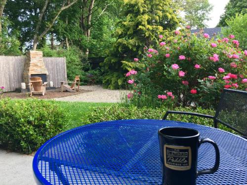 a coffee mug sitting on a blue table in a garden at The Platinum Pebble Boutique Inn - Adults Only Property in Harwich Port