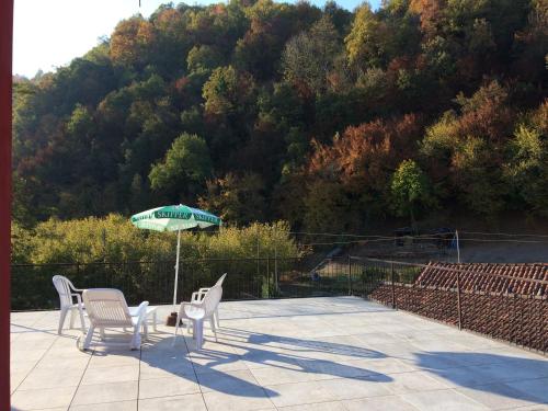 a patio with a table and chairs and an umbrella at B&B La Ceramica Moline in Vicoforte