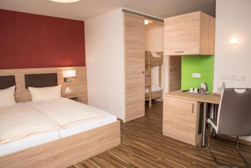 a hotel room with a bed and a desk at Gasthof zum Goldenen Lamm in Wettelsheim