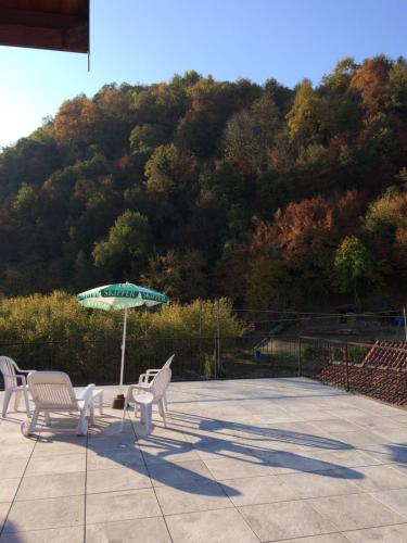 a patio with a table and chairs and an umbrella at B&B La Ceramica Moline in Vicoforte