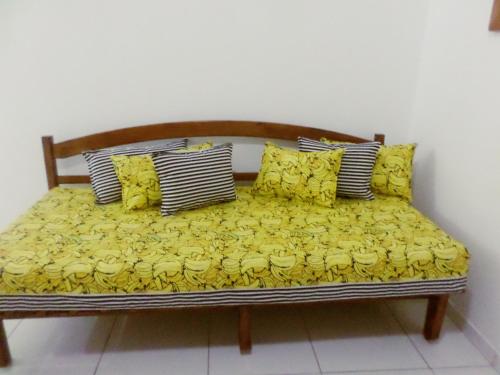 Una cama con sábanas amarillas y almohadas. en Casa para temporada, en Prado