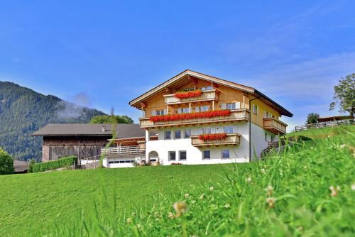 una casa en una colina con un campo verde en Jaiterhof, en Funes