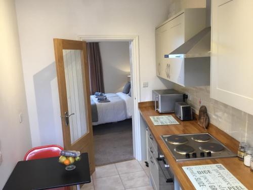 a kitchen with a counter top and a room with a bed at Mount Pleasant Apartments in Beaumaris