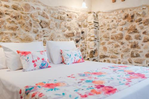 a bed in a room with a stone wall at Navazos loft in Benaocaz