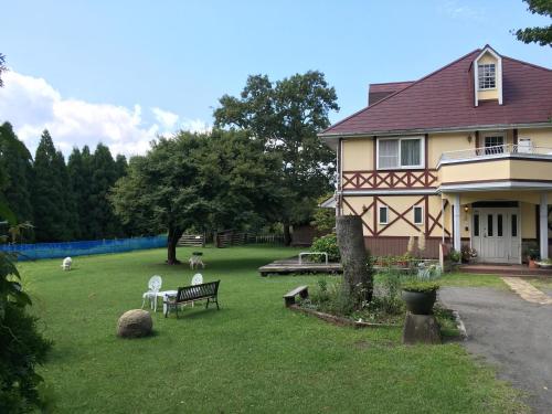 a house with a bench in front of a yard at A private retreat Cotton Club Cottage in Takamori