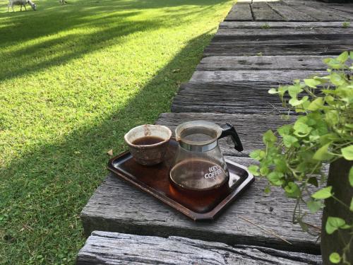 a tea kettle and a cup on a tray on a table at A private retreat Cotton Club Cottage in Takamori