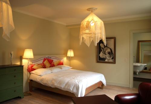 a bedroom with a bed and a chandelier at Le Vaudeville in Brussels