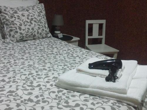 ein schwarzes Telefon auf den Handtüchern auf dem Bett in der Unterkunft Jualis Guest House in Porto