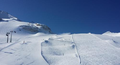a snow covered slope with a ski lift on a mountain at Landhaus Mader Hintertux in Tux