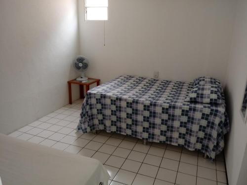 1 dormitorio con 1 cama con manta a cuadros en Cond. Village Van Cartier, en Fortaleza
