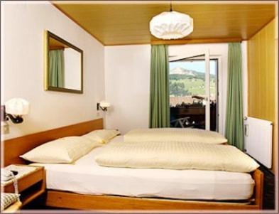 a bedroom with a large bed with a window at Garni Sayonara in Selva di Val Gardena