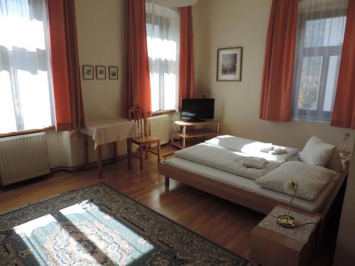 a bedroom with a bed and a table and windows at Gasthof zum Richter in Mühldorf