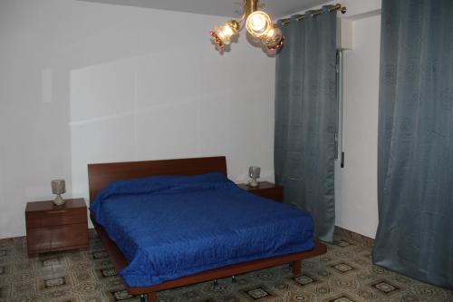 IsnelloにあるLa Tanaのベッドルーム1室(青い掛け布団付きのベッド1台付)