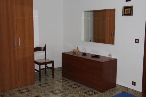 IsnelloにあるLa Tanaのドレッサー、椅子、鏡が備わる客室です。