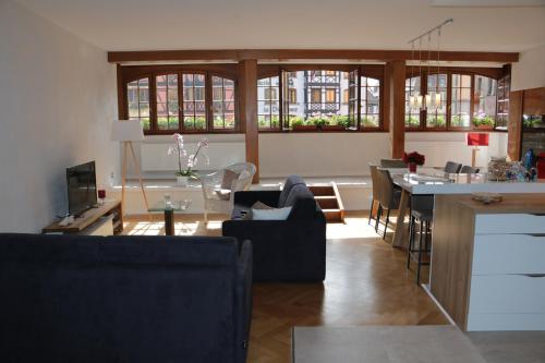 un salon avec un canapé et une table avec des chaises dans l'établissement La Fontaine Sainte Odile, à Obernai