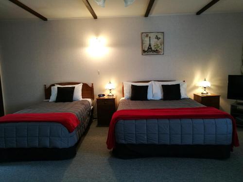 Habitación de hotel con 2 camas y 2 lámparas en Hacienda Motel, en Invercargill