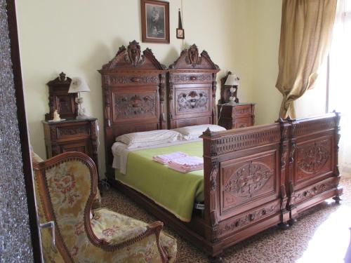 a bedroom with a large wooden bed and a chair at Casa della piazza in Radicofani
