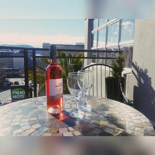 a bottle of wine sitting on a table with a wine glass at Dunedin Palms Motel in Dunedin