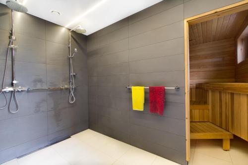 a bathroom with a shower and yellow and red towels at Sun Villa in Imatra
