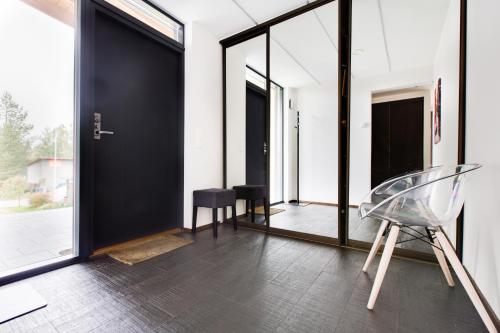 a room with black doors and a glass chair at Sun Villa in Imatra