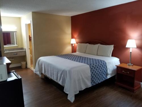 a hotel room with a large bed and two lamps at Econo Inn - Ormond Beach in Ormond Beach