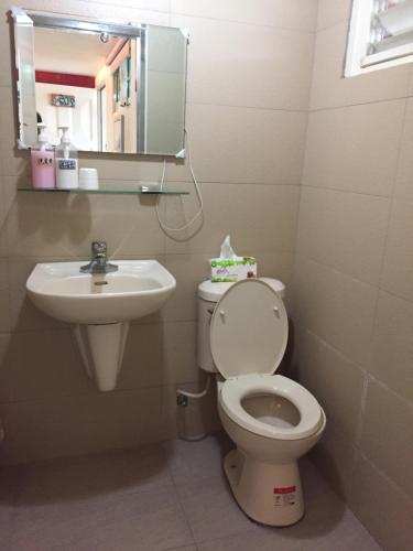 y baño con lavabo, aseo y espejo. en Kawada House Homestay, en Xiluo
