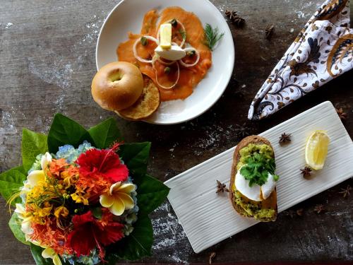 a table topped with plates of food and flowers at Tandjung Sari Hotel in Sanur
