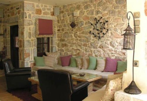 a living room with a couch and a stone wall at Katafigi in Pirgos Dhirou
