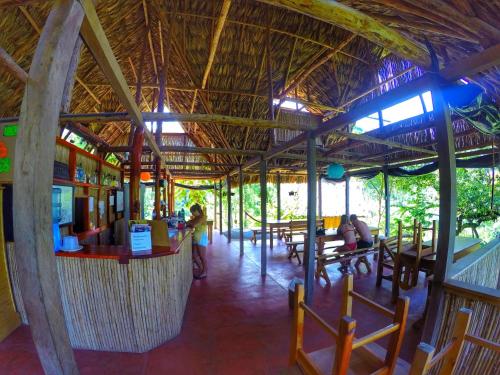 a restaurant with a bar with people sitting at tables at Vista Verde Lodge in Lanquín