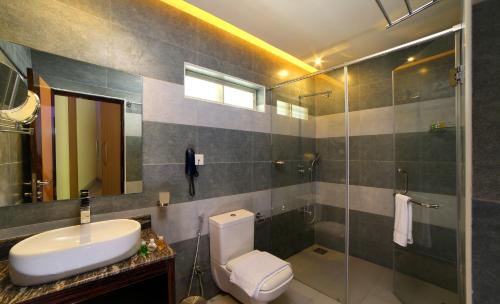 a bathroom with a toilet and a sink and a shower at Casa Rio Resorts Athirappilly in Athirappilly