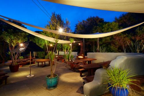 a patio with tables and umbrellas at night at Awaroa Lodge in Awa-iti